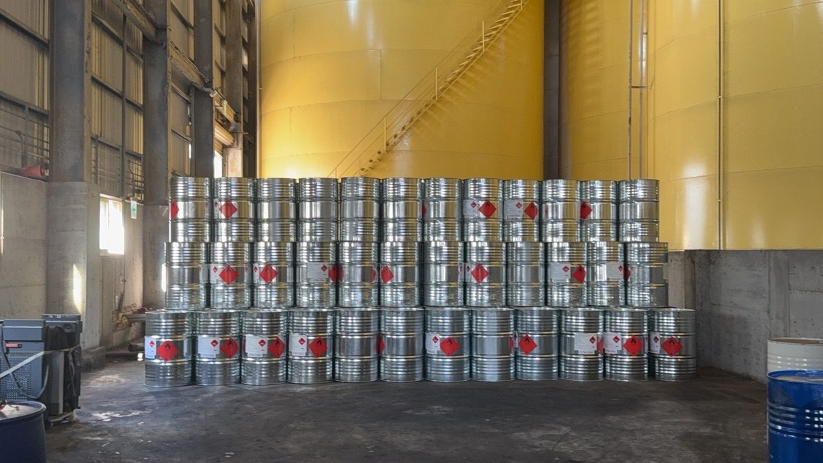 Labeled drums stored in front of bulk tanks at CFI